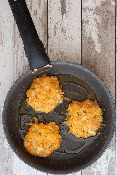 Patties in a frying pan before cooking.