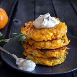 4 Pumpkin fritters stacked with mayo on top.