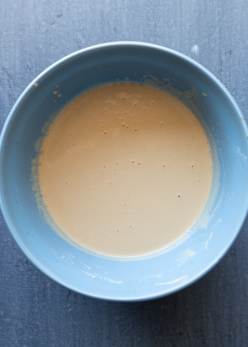 The wet ingredients whisked in a blue bowl.