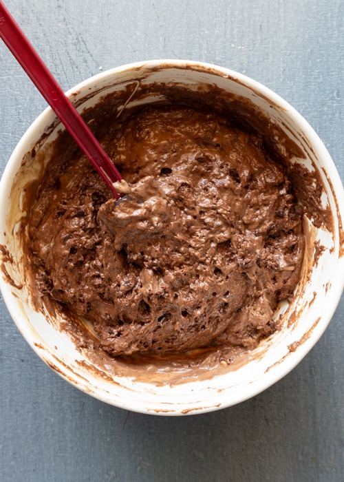 Mixing the wet and dry in a white bowl.