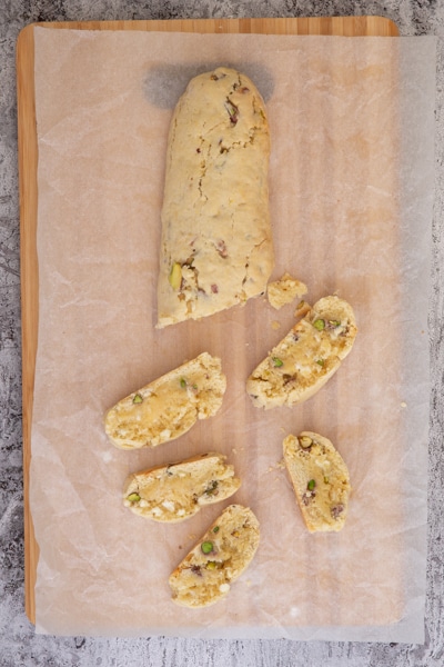 Slicing the baked dough on a wooden board.