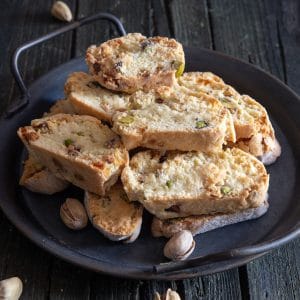 Pistachio biscotti on a black plate.