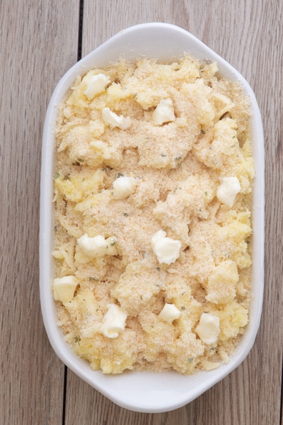 The bread crumb mixture and dots of butter on top of the mashed potato.