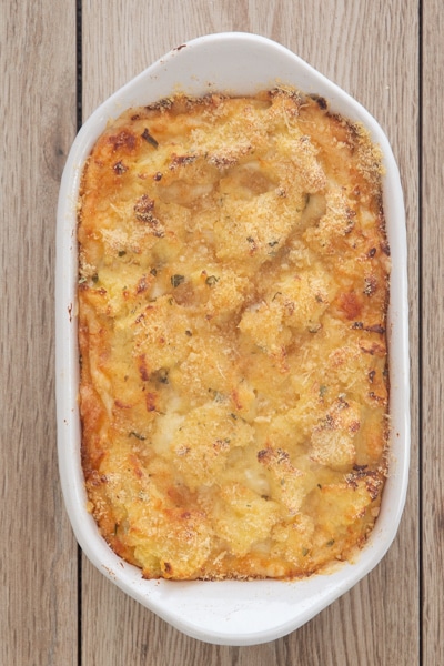 The potato casseroled baked in a white baking dish.