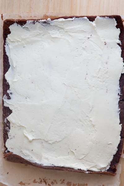 Cake unrolled and frosting spread on top.