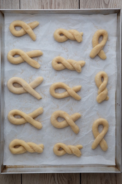 The formed cookies on a parchment paper cookie sheet.