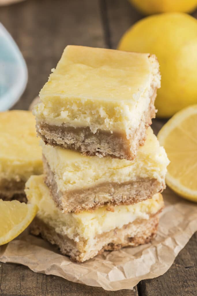 Three lemon cheesecake squares stacked.
