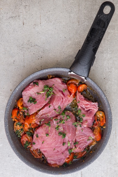 Adding the tuna steaks to the pan.