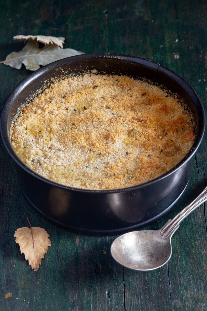 Rice casserole in a black pan with a silver spoon.