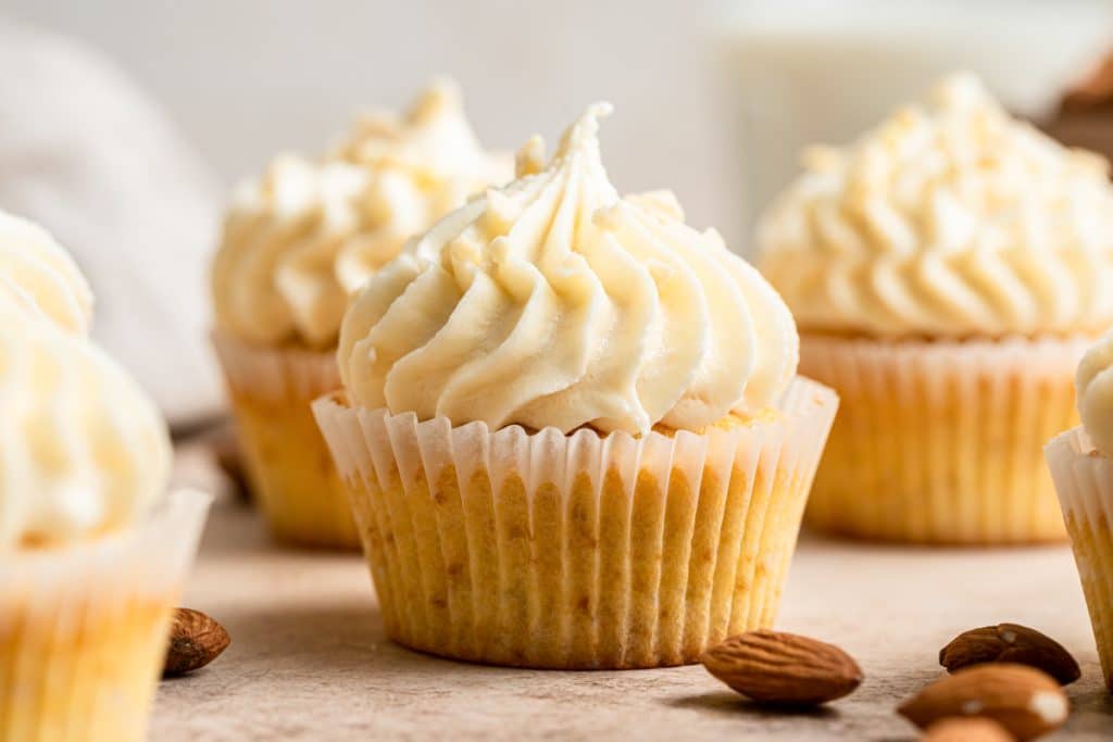 Vanilla almond cupcakes on a grey board.