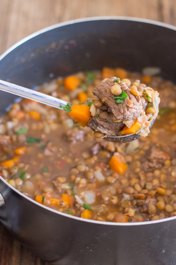 Lentil and beef stew with some on a ladle.