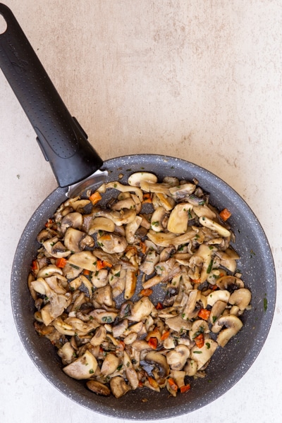 The cooked mushrooms in the black pan.