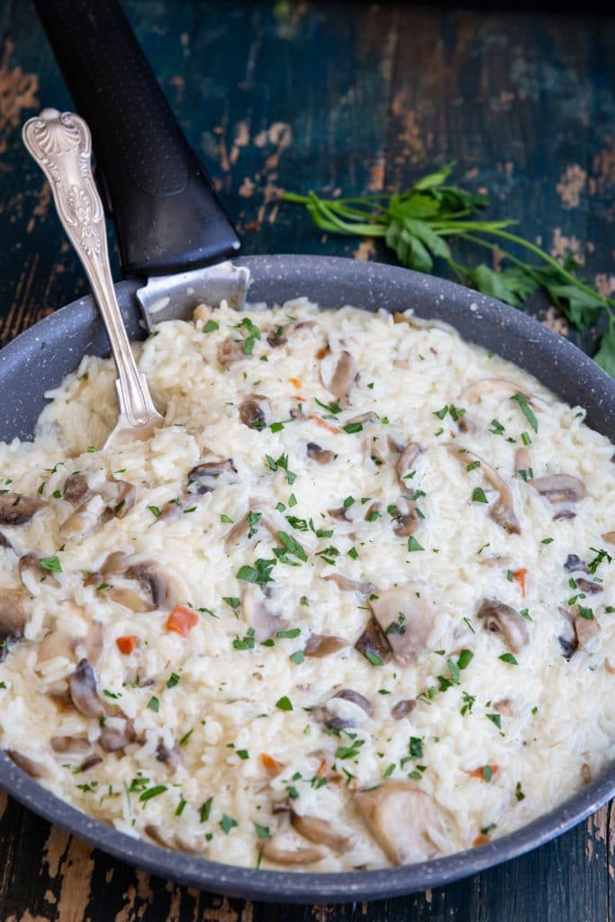 Mushroom risotto in a black pan.