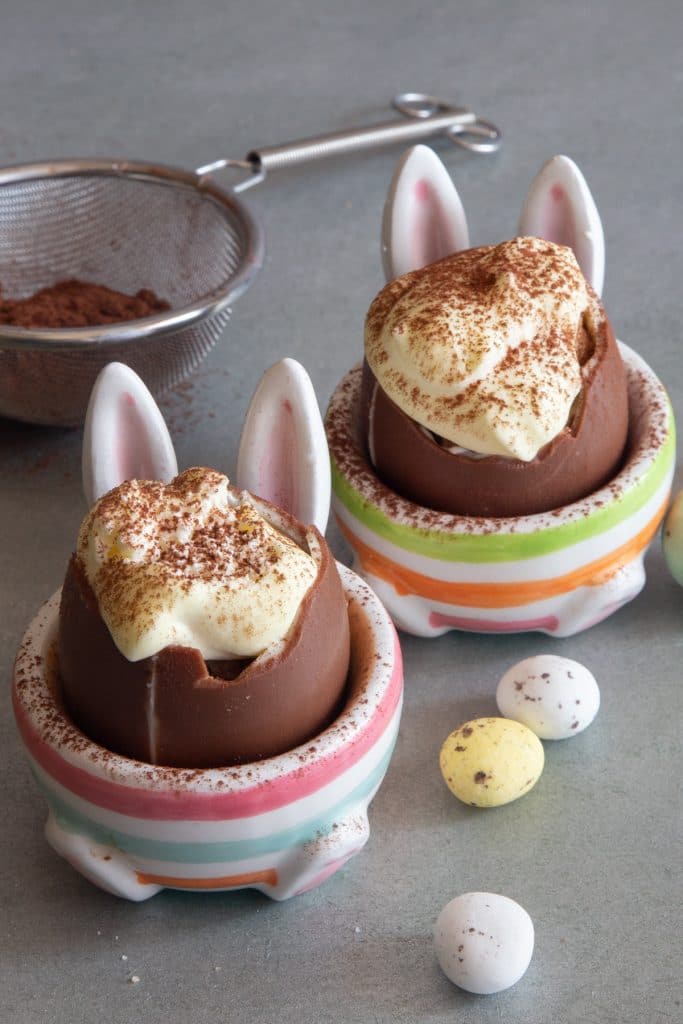 Small chocolate eggs in egg cups.