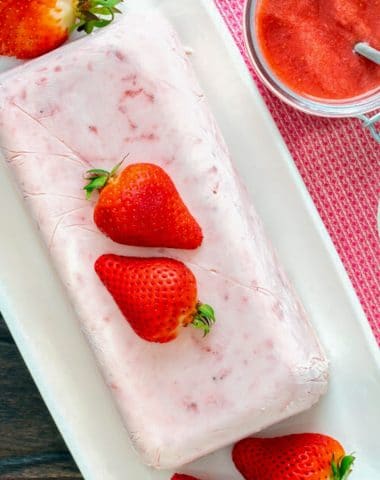Semifreddo on a white plate with strawberries.