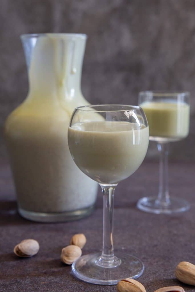 Pistachio liqueur in a bottle and in 2 glasses.