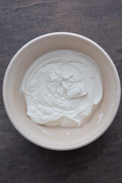 Gelatine mixed into the yogurt in a white bowl.
