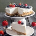 Greek yogurt pie on a white cake stand and a slice on a white plate.