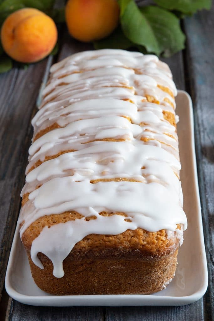 Apricot bread with glaze on a white plate.
