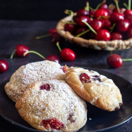 Cherry cookies on a black plate.
