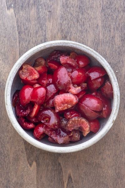 Pitted and chopped cherries in a white bowl.