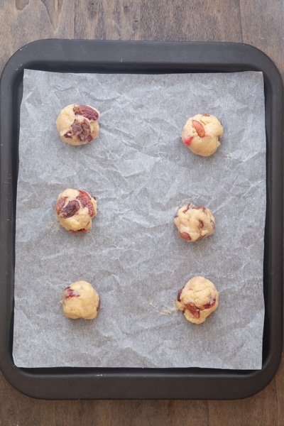 Cookies before baked on a parchment paper lined cookie sheet.