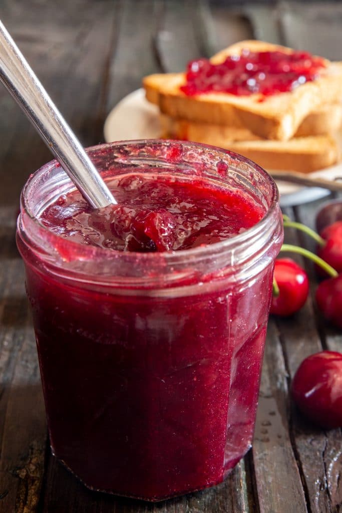 Cherry jam in a glass jar.
