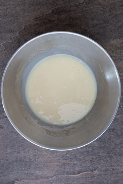 The sweetened condensed milk and vanilla mixed in a silver bowl.