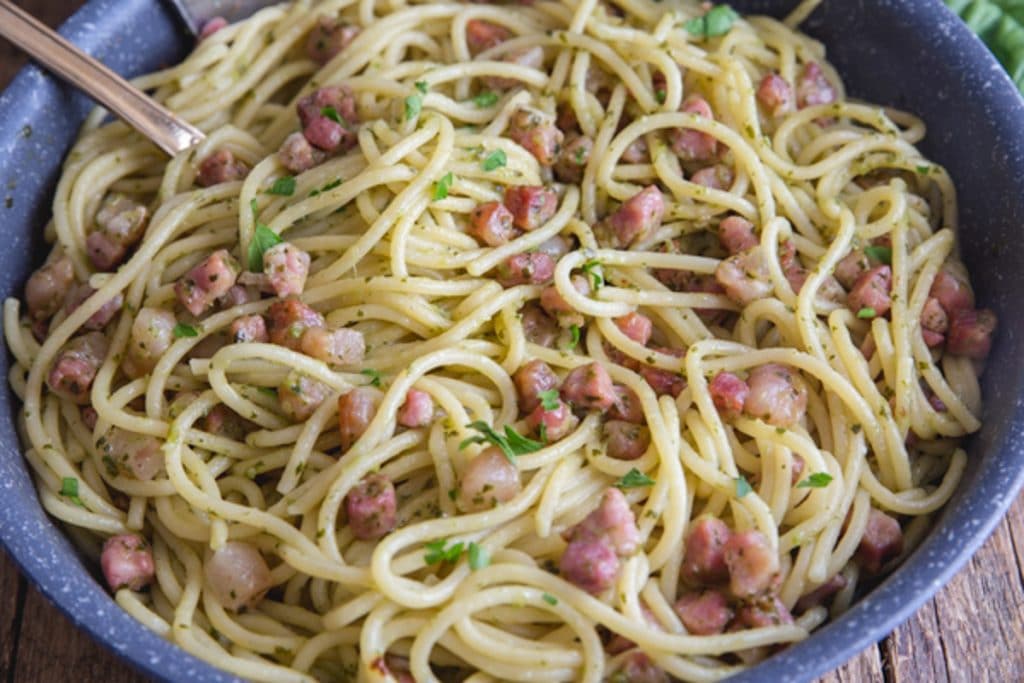 Pasta in the pan cooked with pesto and pancetta.