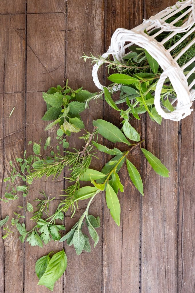 Herbs falling from a white basket.