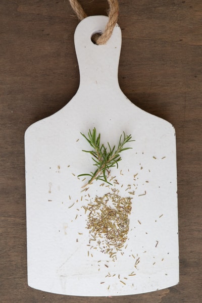 rosemary fresh and dried on a white board.