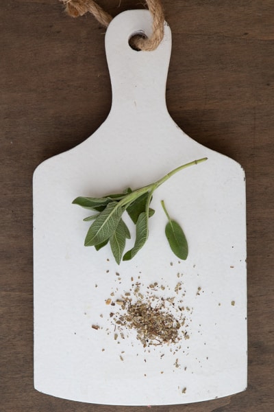 Sage fresh and dried on a white board.