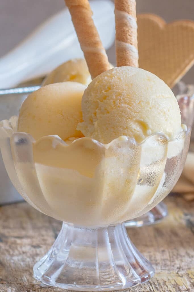 Two scoops of ice cream in a glass bowl.