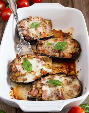 eggplant boats in a white baking dish with a fork.