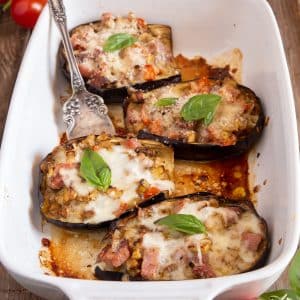 eggplant boats in a white baking dish with a fork.
