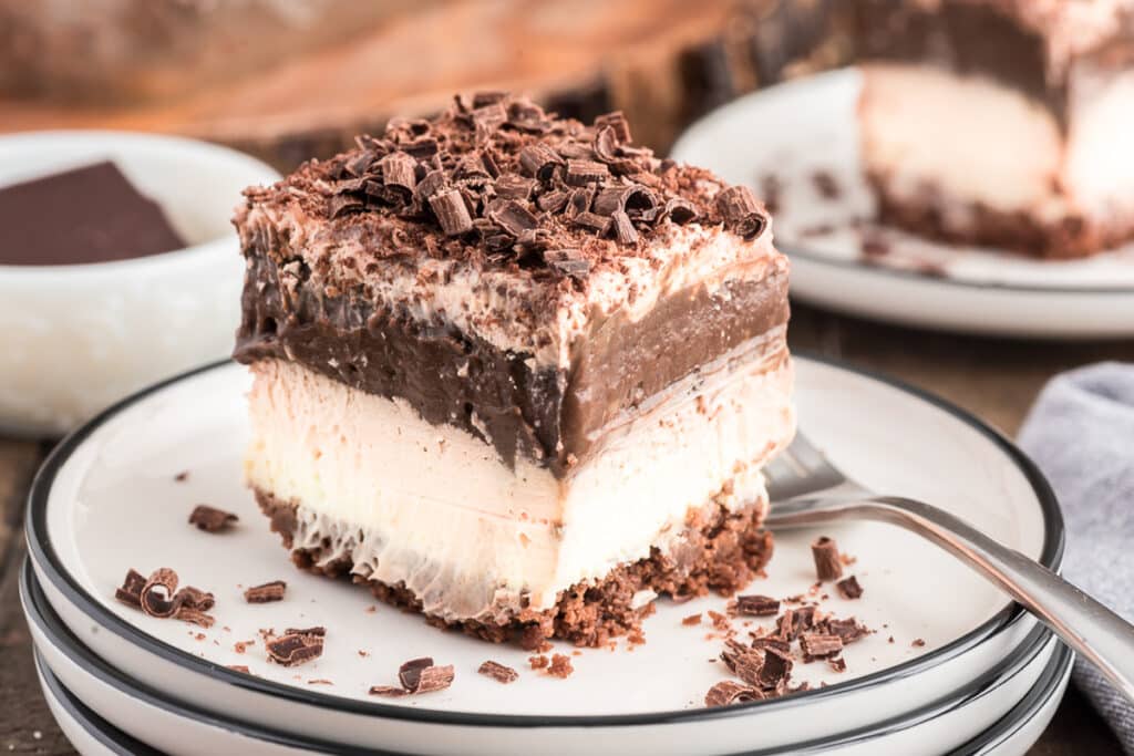 A slice of no bake cake on a white plate with a fork.