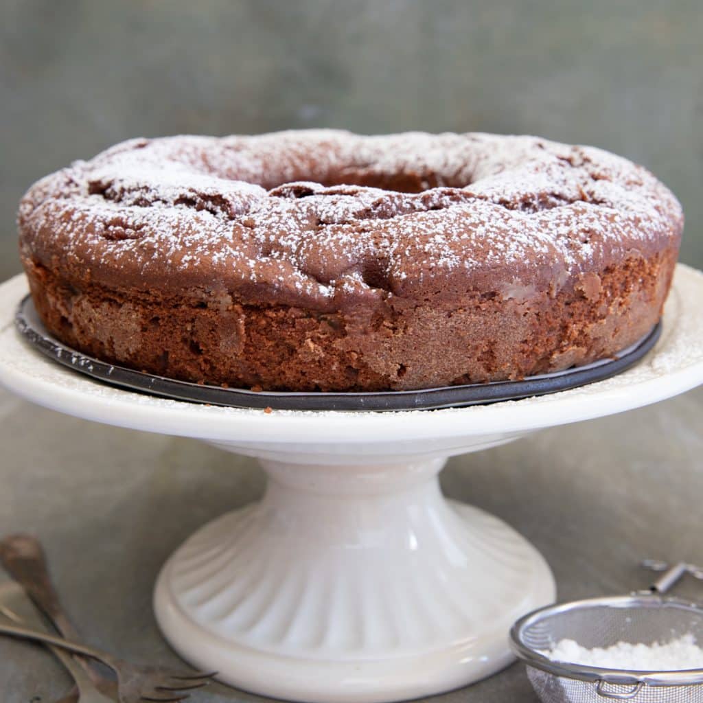 Pear cake on a white cake stand.