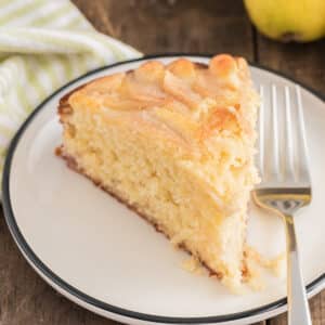 A slice of pear cake on a small white plate.