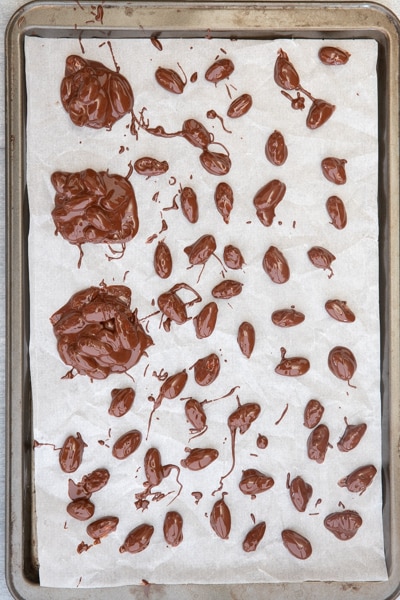 Almonds and clusters on a parchment paper sheet.