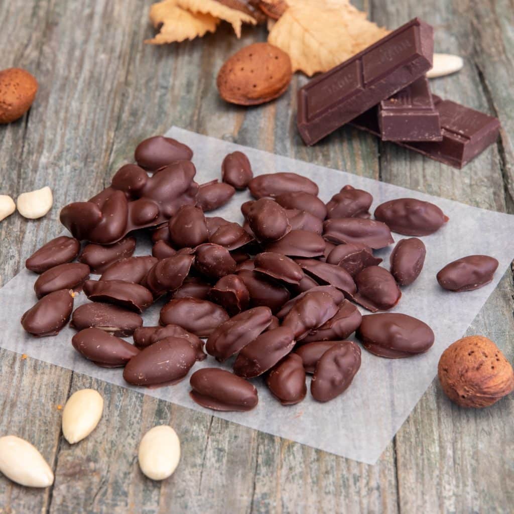 Chocolate covered almonds on parchment paper.