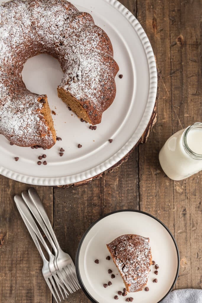 The cake on a white plate with a slice on a small plate.