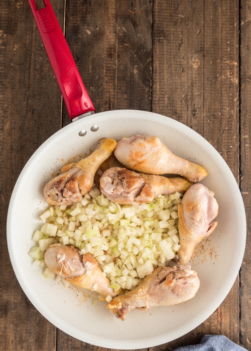 Cooking the chicken and onions in the pan.