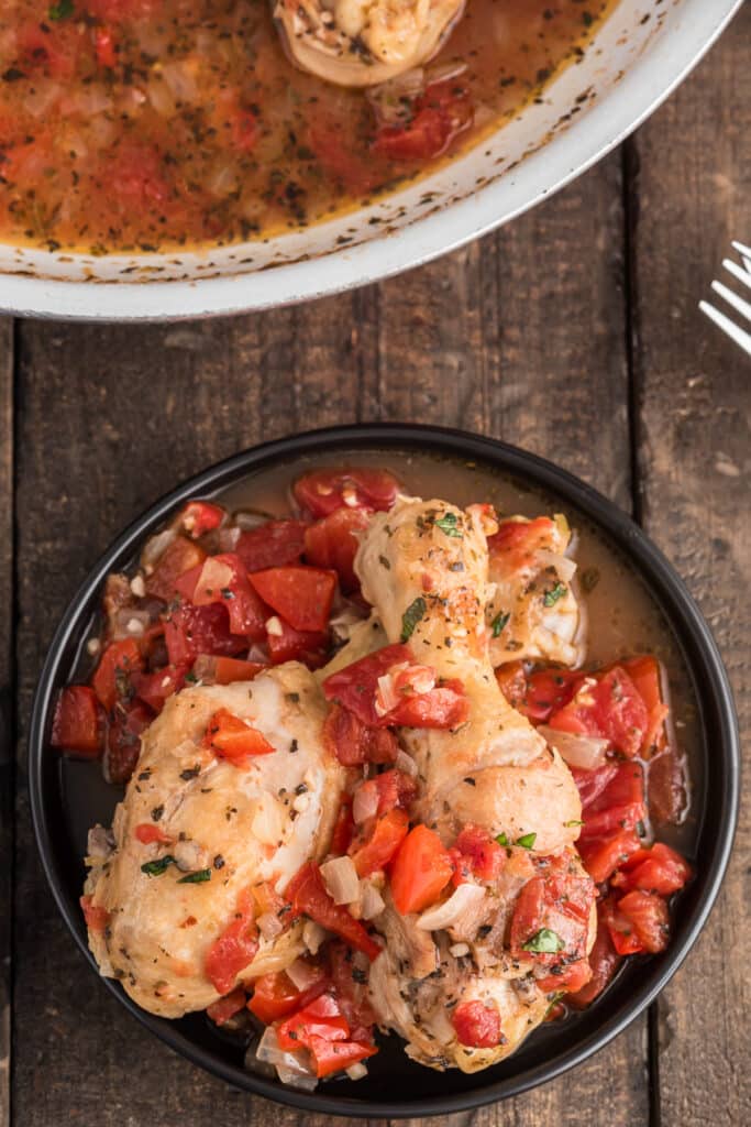 Chicken in the pan and some on a black plate.
