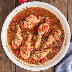 Chicken cacciatore in a white pan.