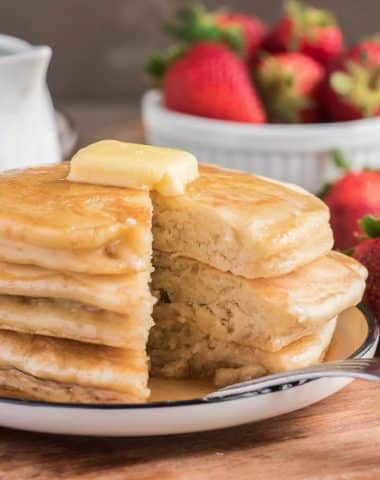 Pancakes stacked with syrup and butter.