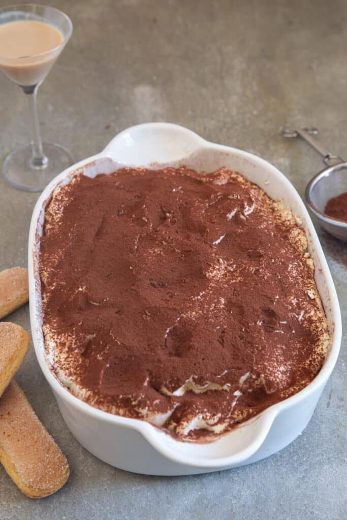 Tiramisu in the pan with cocoa on top.