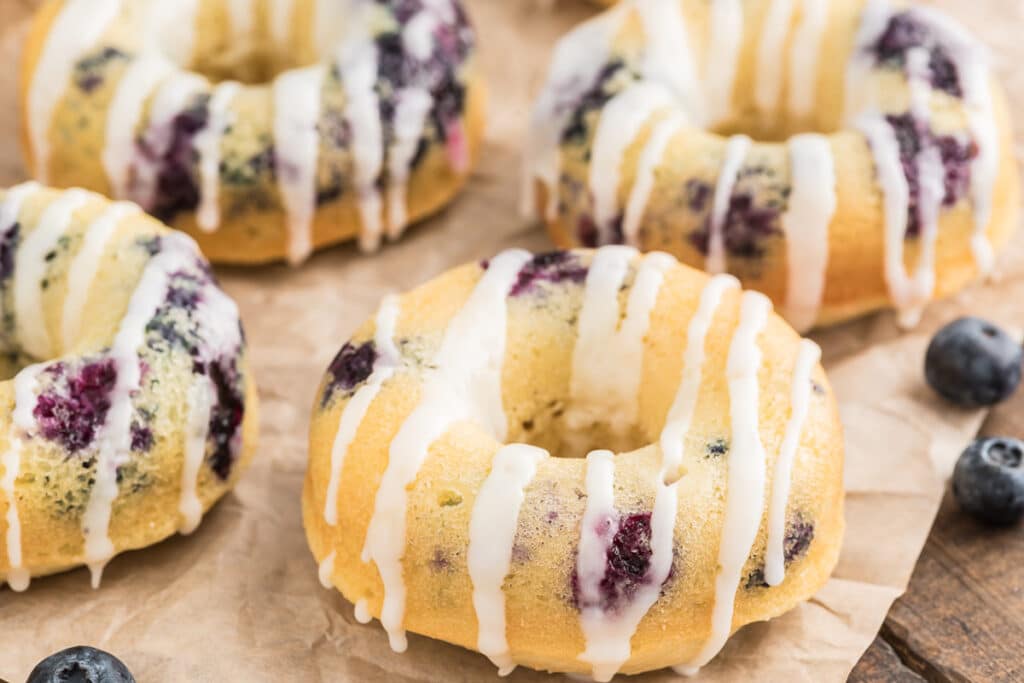 Lemon blueberry donuts on brown paper.