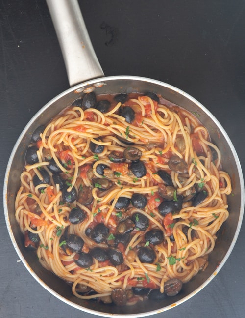 The spaghetti and pasta water added and tossed with the sauce.