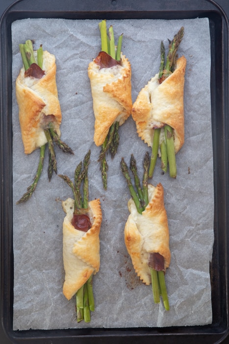 Baked prosciutto bundles on the baking sheet.