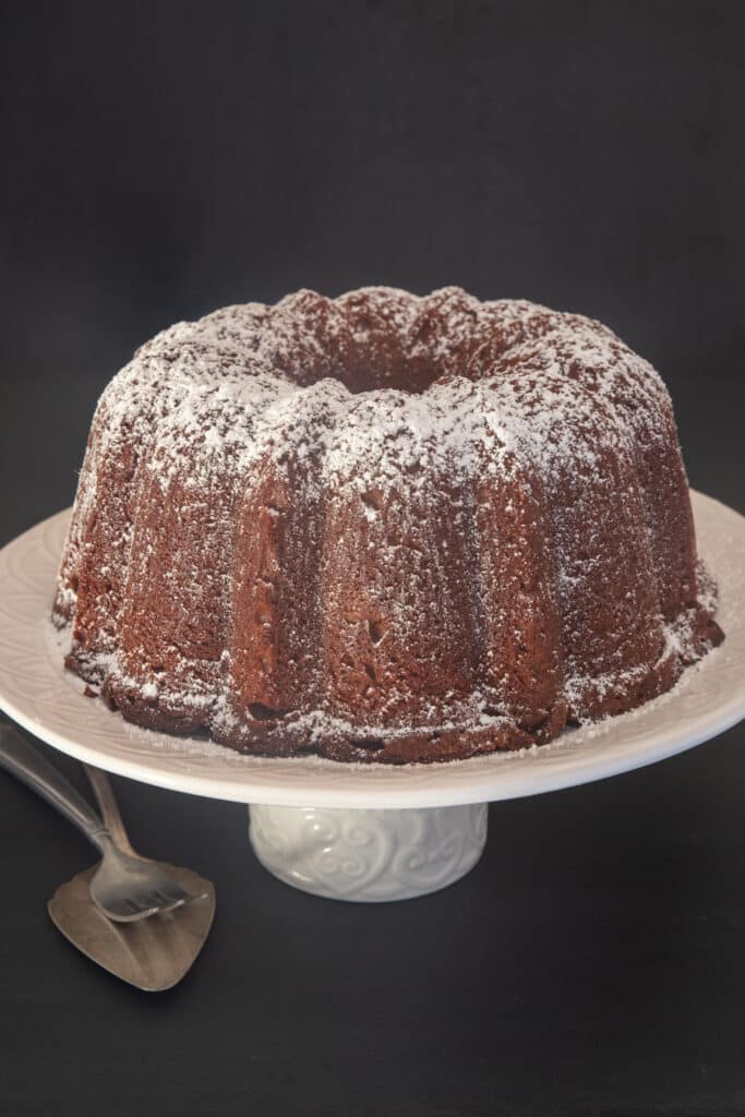 Ricotta chocolate cake on a white cake stand.